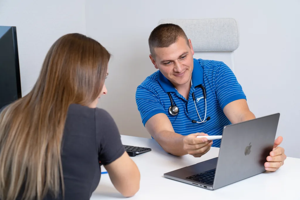 Arzt bespricht die Befunde mit einer Patientin am Bildschirm