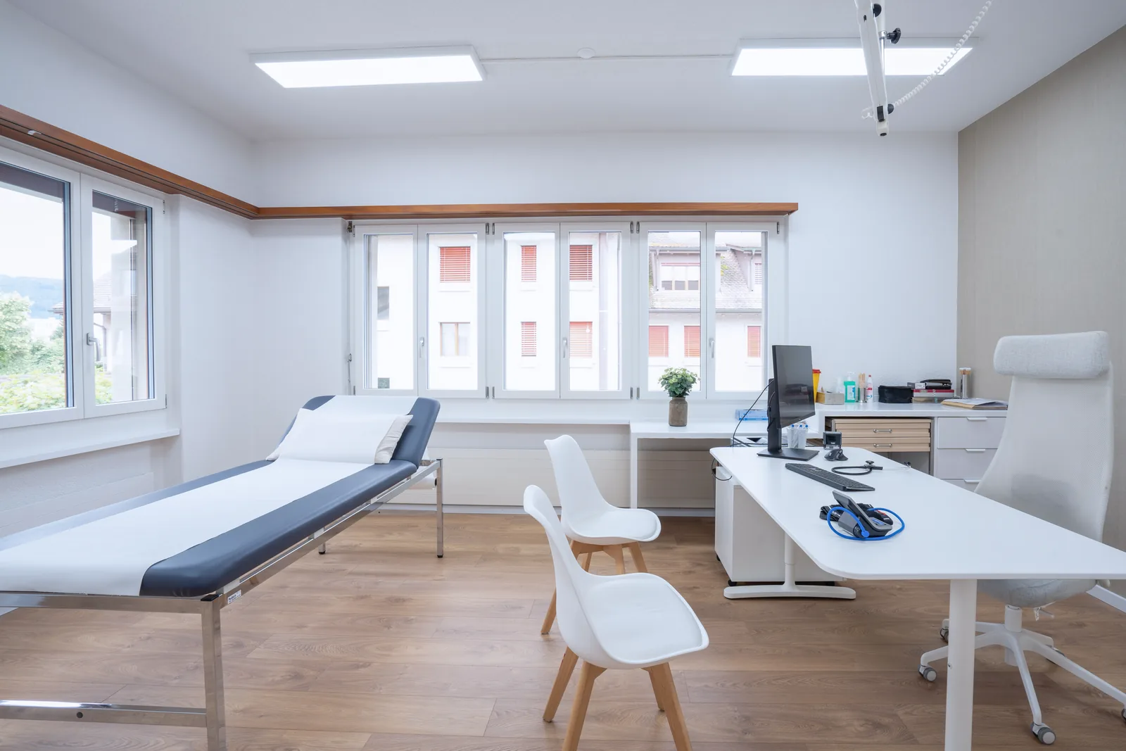 Sprechzimmer mit Untersuchungsliege und Arbeitsplatz